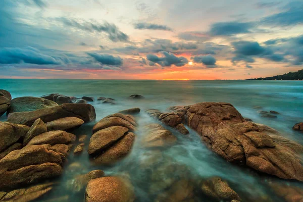 Sunset over rocks beach — Stock Photo, Image