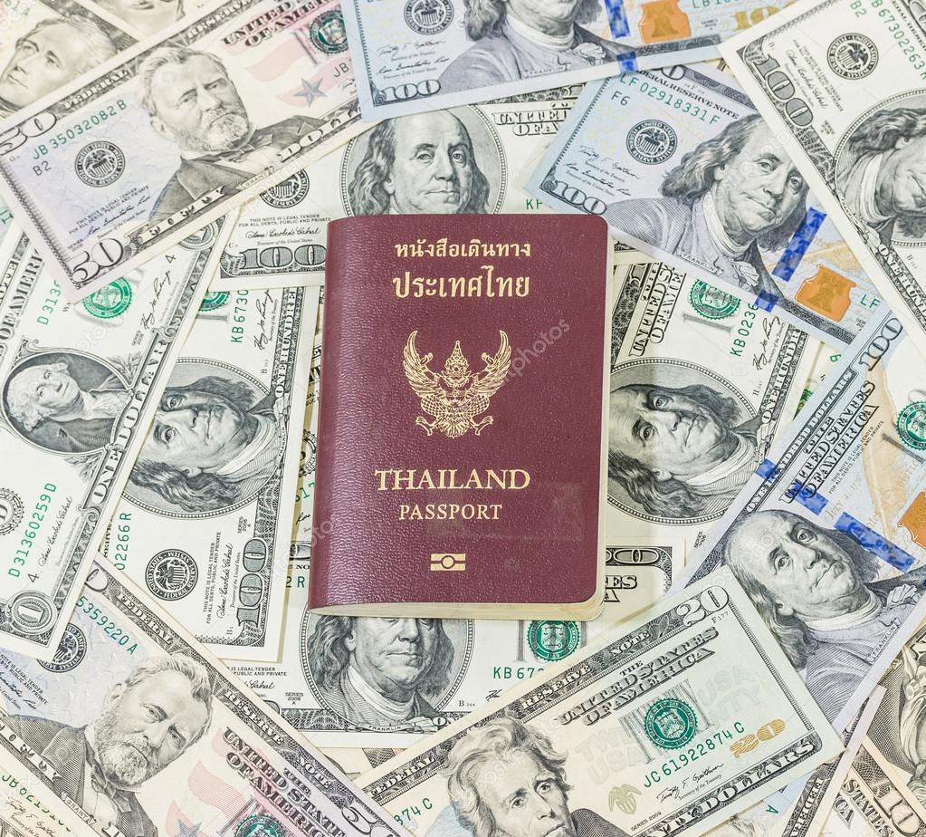 Dollars pile as background and Passport Thailand