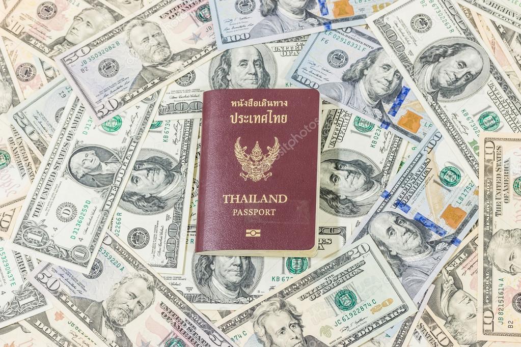 Dollars pile as background and Passport Thailand