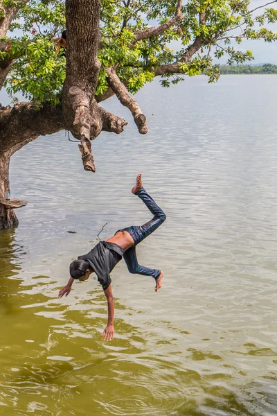 Myanmar children were playing by jumping from the tree at the river near U Bein Bridge — Stock Photo, Image