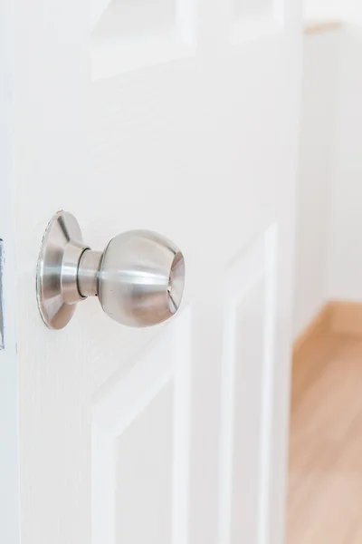 Detail of a metallic knob on white door — Stock Photo, Image