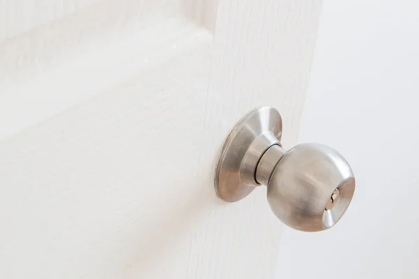 Dettaglio di una manopola metallica su porta bianca — Foto Stock