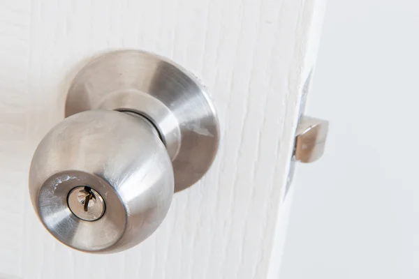 Detail of a metallic knob on white door — Stock Photo, Image