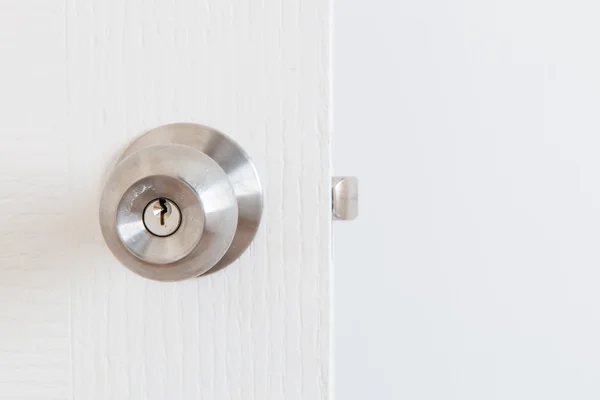 Detail of a metallic knob on white door — Stock Photo, Image