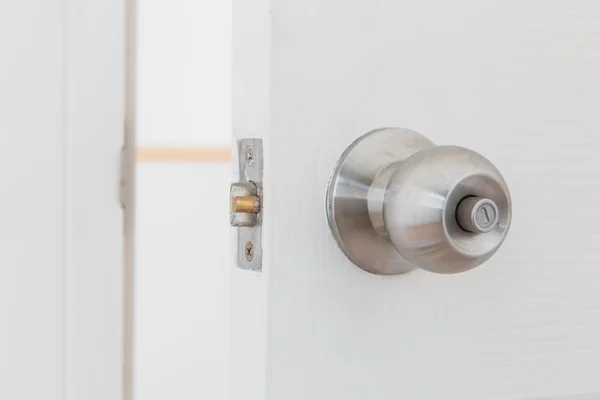 Detail of a metallic knob on white door — Stock Photo, Image