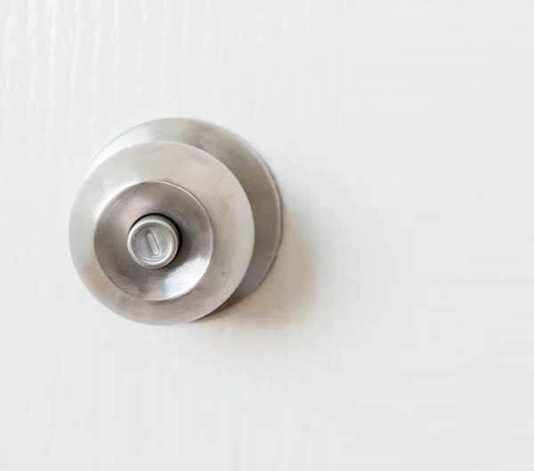 Detail of a metallic knob on white door — Stock Photo, Image