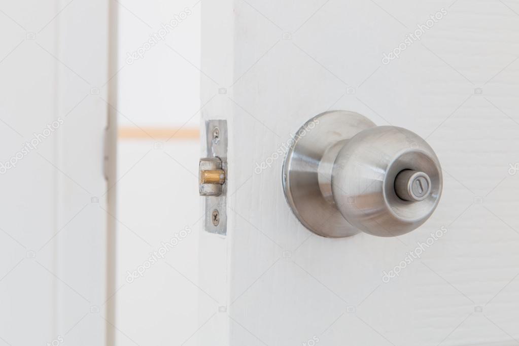 Detail of a metallic knob on white door