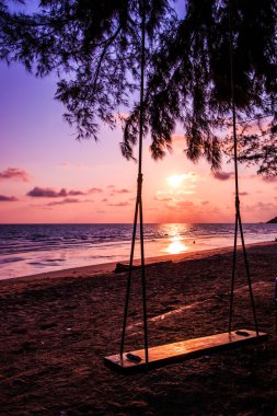 Sahilde güzel günbatımı üzerinde salıncak