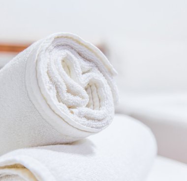 Beyaz yatak ve yatakta havlu