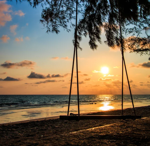 Качели на красивом закате на пляже — стоковое фото