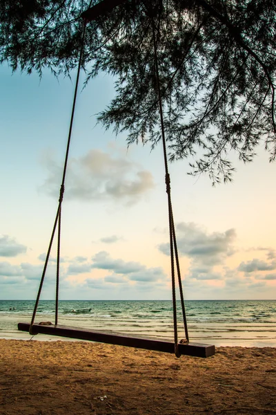 Качели на красивом закате на пляже — стоковое фото