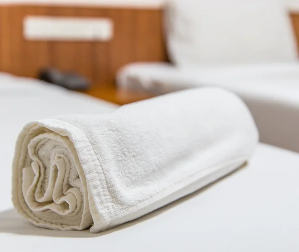 Белая кровать и полотенца на кровати — стоковое фото