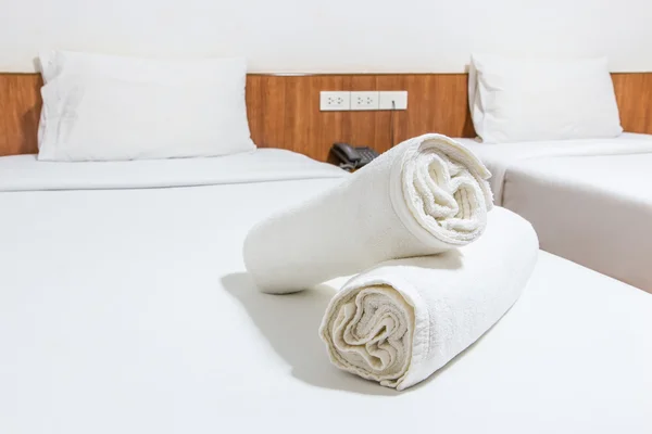 Белая кровать и полотенца на кровати — стоковое фото