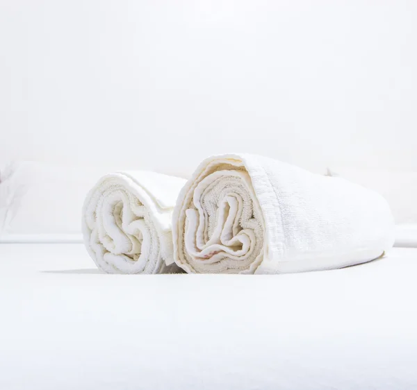 Beyaz yatak ve yatakta havlu — Stok fotoğraf