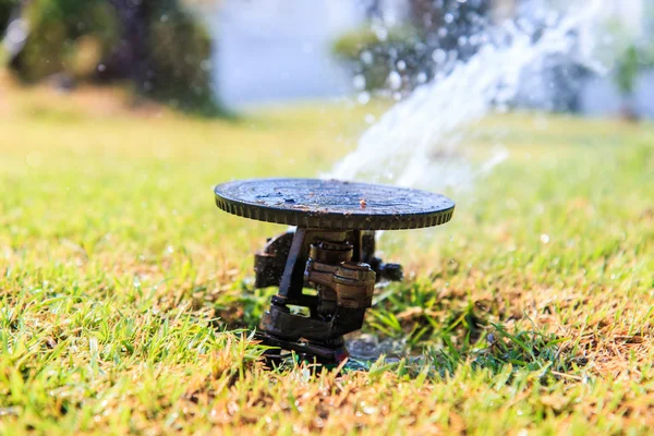 Sprinkler system in a farm field grass — Stock Photo, Image