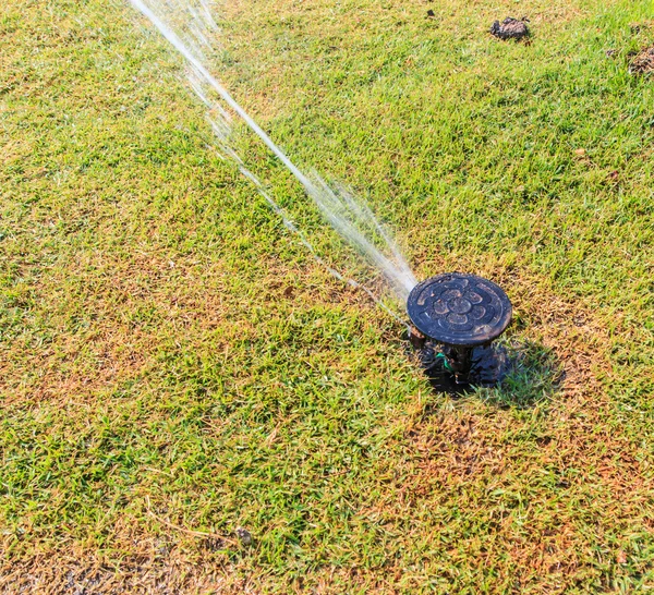 Sprinkler system in a farm field grass — Stock Photo, Image