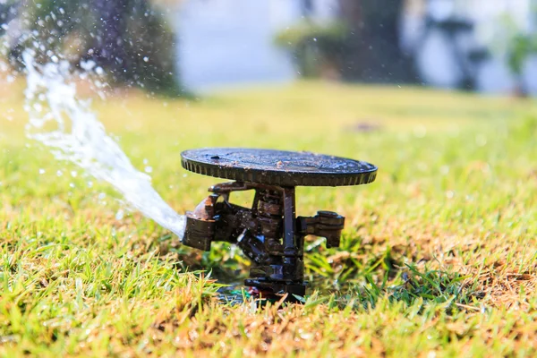 Sprinkler system in a farm field grass — Stock Photo, Image