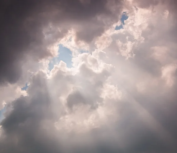 Lichtstrahlen, die durch dunkle Wolken scheinen — Stockfoto