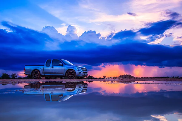 Auto en zonsondergang blauwe hemel — Stockfoto