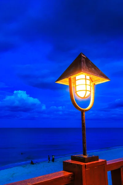 Crepúsculo luz lâmpada e praia — Fotografia de Stock