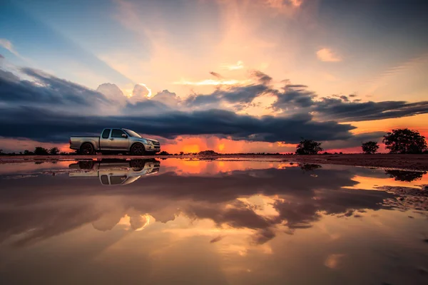 Auto a západu slunce obloha — Stock fotografie