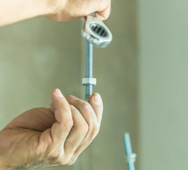 Manos de trabajador con tuerca — Foto de Stock