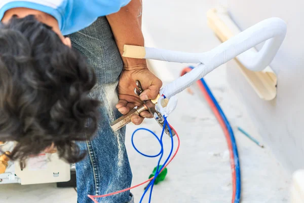 Lavoratore con nuovo condizionatore — Foto Stock