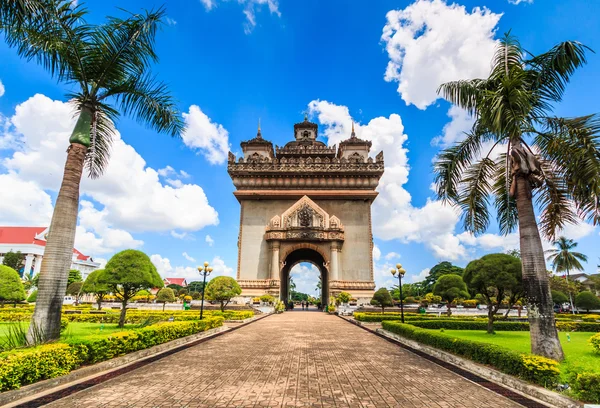 Patuxai ve palmiye ağaçları — Stok fotoğraf