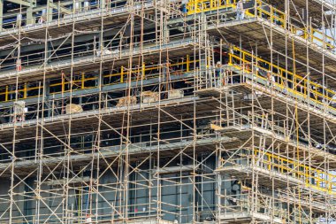 Yeni inşa edilmiş bir binada mühendisler ve inşaat işçilerinin çalıştığı bir şantiye..