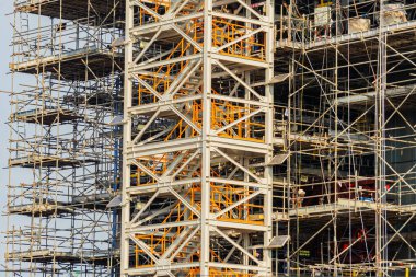 Yeni inşa edilmiş bir binada mühendisler ve inşaat işçilerinin çalıştığı bir şantiye..