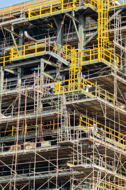 Yeni inşa edilmiş bir binada mühendisler ve inşaat işçilerinin çalıştığı bir şantiye..