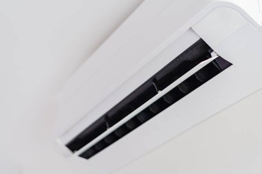 Odadaki klima beyaz duvarda asılı..