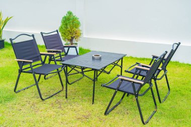 Masa ve sandalye yeşil çimenlikte.