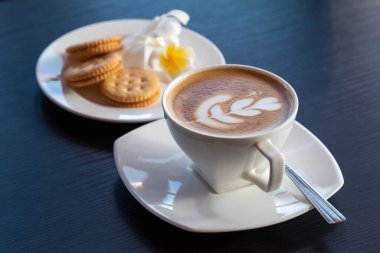 Siyah bir masada beyaz bir fincanda kahve.