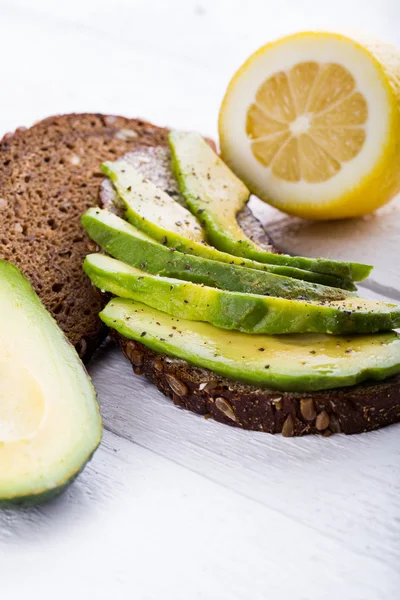 Sandwich de aguacate sobre pan de centeno oscuro . Imagen de stock