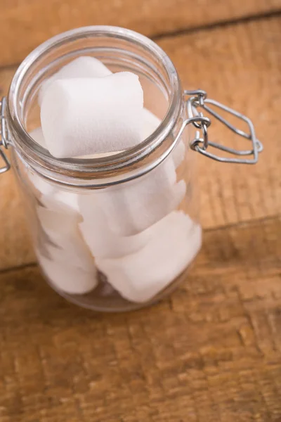 Söta marshmallows i en glasburk på träbord. — Stockfoto