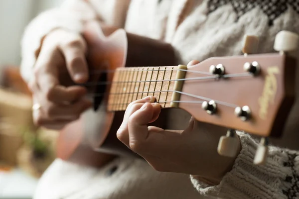 La mano de la mujer tocando ukelele . Fotos de stock