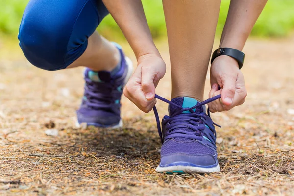 Primer plano de la mujer atando cordones de zapatos en el entrenamiento de verano . — Foto de Stock