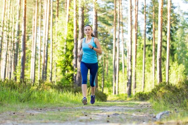 Joven mujer fitness corriendo en el sendero del bosque . — Foto de Stock
