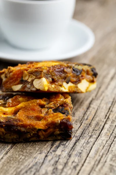 Lezzetli vejetaryen granola pasta dilimi ahşap masa kahve ile.