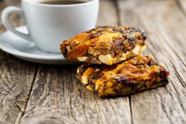 Lezzetli vejetaryen granola pasta dilimi ahşap masa kahve ile.