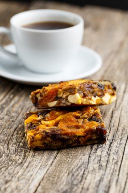 Lezzetli vejetaryen granola pasta dilimi ahşap masa kahve ile.