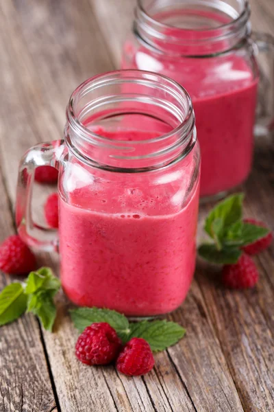 A fából készült asztal ízletes málna smoothie. — Stock Fotó