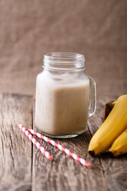 Sağlıklı muz smoothie muz üzerinde ahşap tabl cam kavanoza