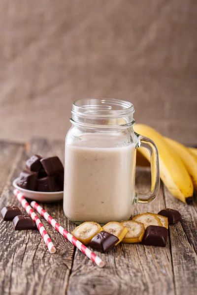 Banana smoothie  with chocolate in glass jar with drinking straw — Stock Photo, Image
