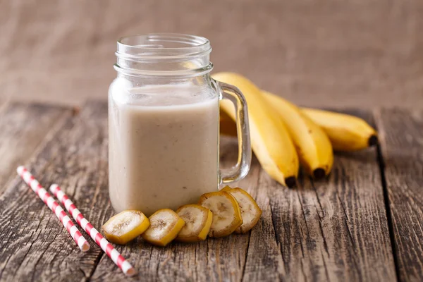 Smoothie aux bananes sain dans un bocal en verre avec bananes sur table en bois — Photo