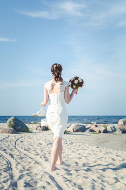 Yalınayak gelin düğün buket ile deniz gidin