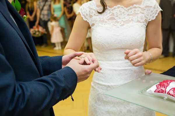 Pengantin pria meletakkan cincin emas di jari mempelai wanita selama cerem pernikahan — Stok Foto