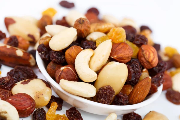 Gemengde noten en sultana's op een plaat op een witte achtergrond — Stockfoto