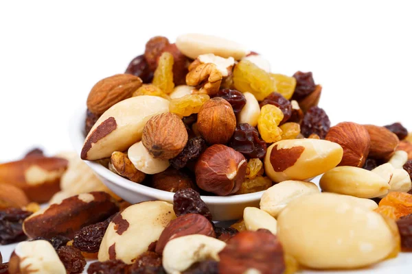 Nueces y sultanas mezcladas en un plato sobre un fondo blanco — Foto de Stock